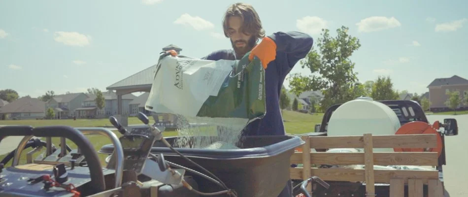 Lawn care professional preparing to fertilize a lawn in Carmel, IN.