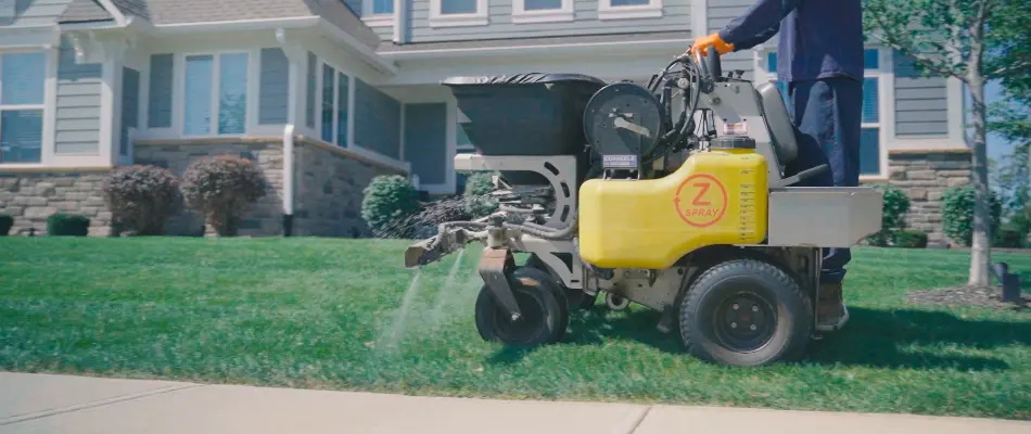 Worker in Carmel, IN, spraying lawn with fertilizer.