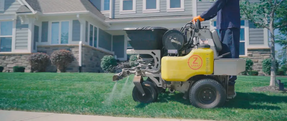 Lawn care employee in Fortville, IN, treating lawn.