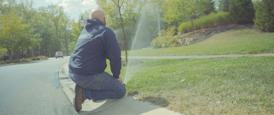 Lawn care employee checking sprinkler system in Carmel, IN.